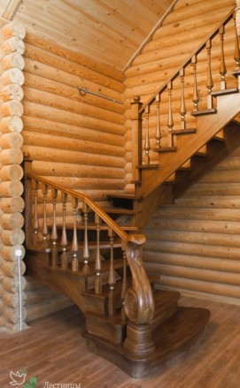 Лестница с резным столбом в загородном деревянном доме.