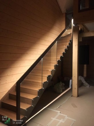 Деревянная лестница в доме со стеклянными ограждениями