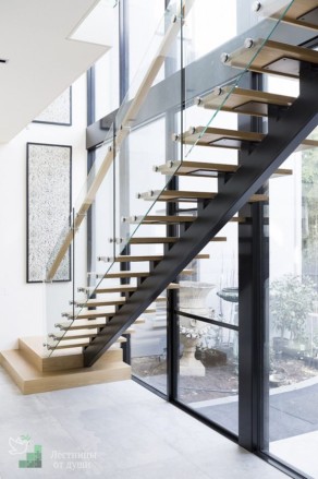 Лестница с деревянными ступенями по металлическим косоурам со стеклом в ограждении